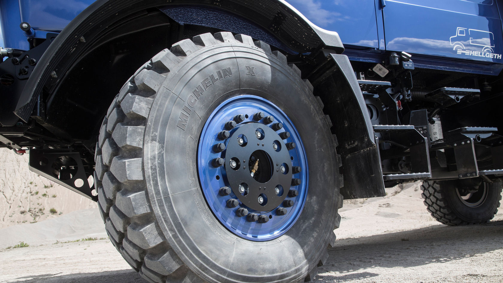 Nahaufnahme des Reifens eines Unimog U 4023, mit einem kräftigen, grobstolligen Profil.