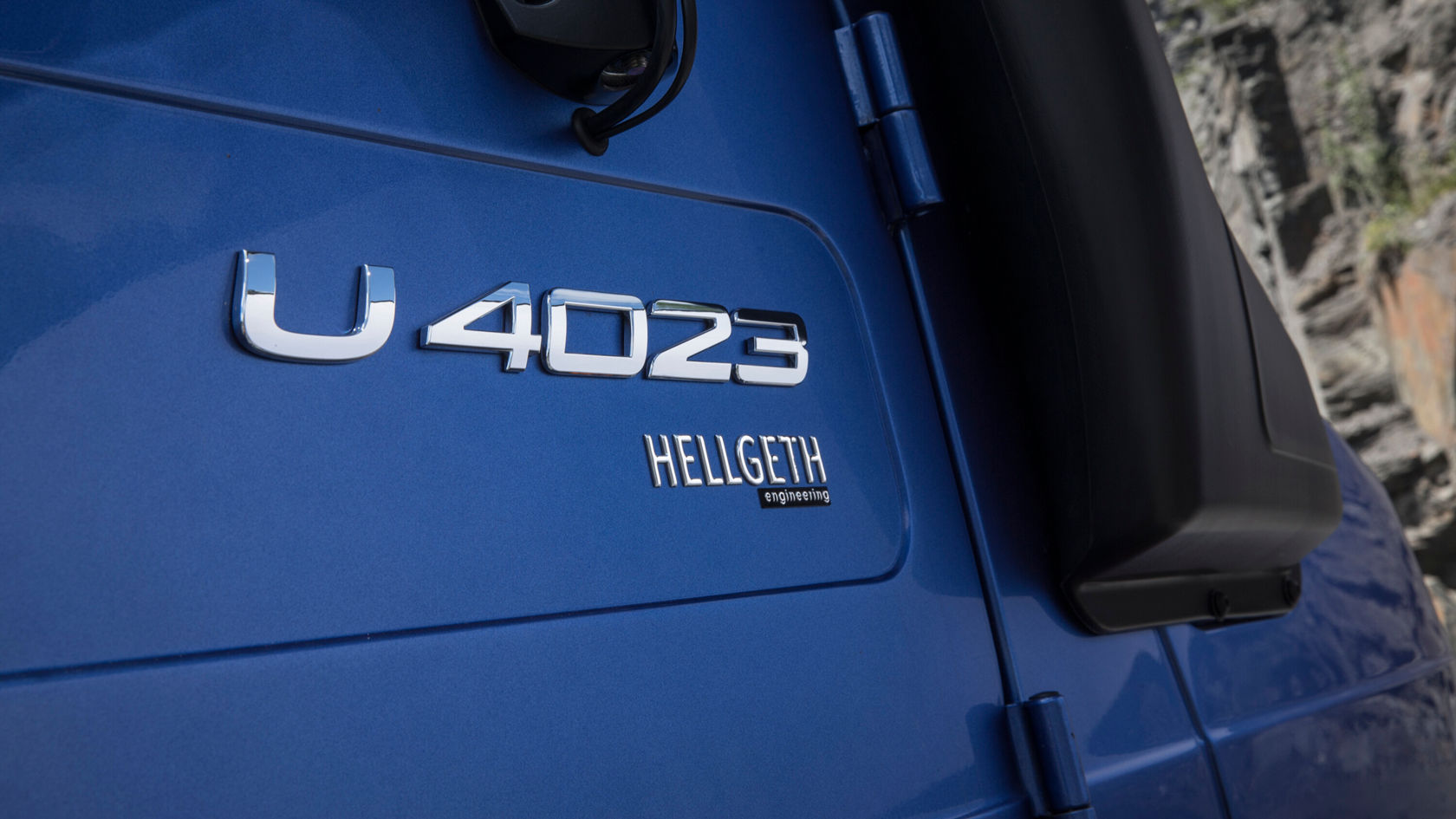 Nahaufnahme eines blauen Unimog mit dem Schriftzug "U 4023" und "HELLGETH engineering".