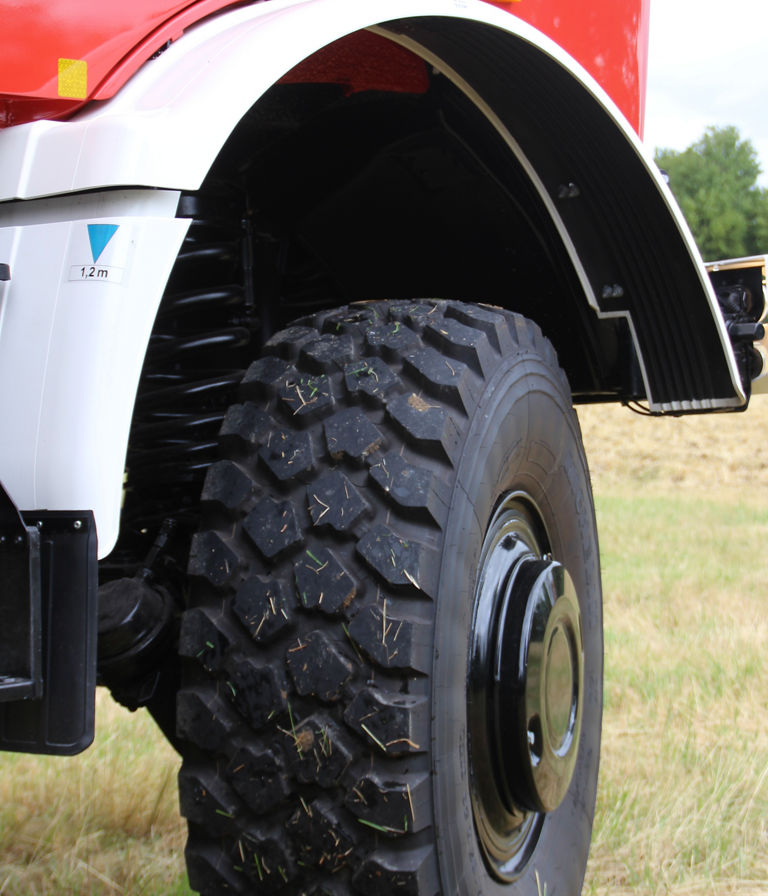 Ein seitlicher Blick auf das Rad eines Geländewagens von Mercedes-Benz, das tiefes Profil und robuste Gummierung zeigt, ideal für Offroad-Bedingungen.