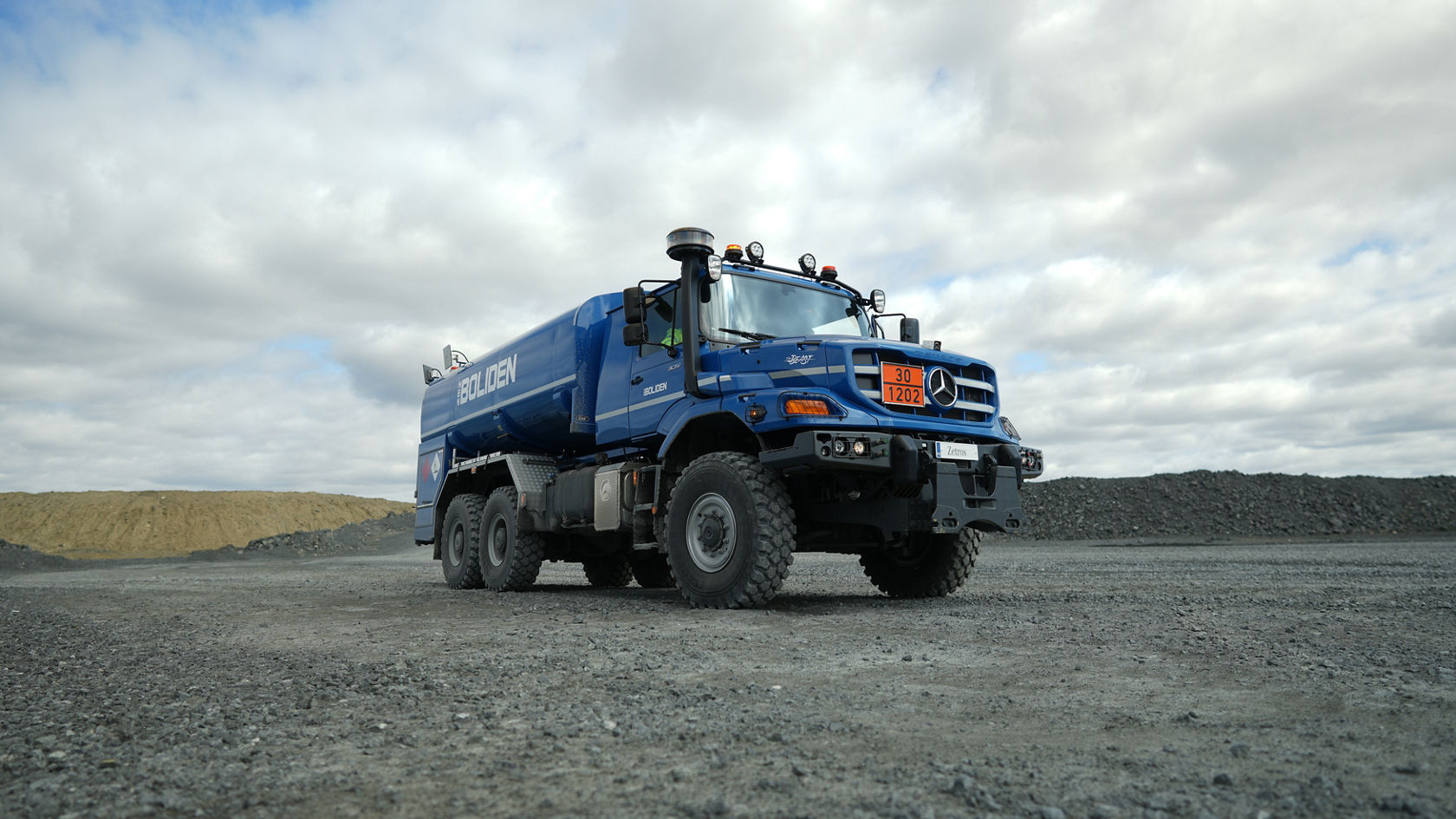 A blue Mercedes-Benz Zetros tanker is parked on a gravel surface.