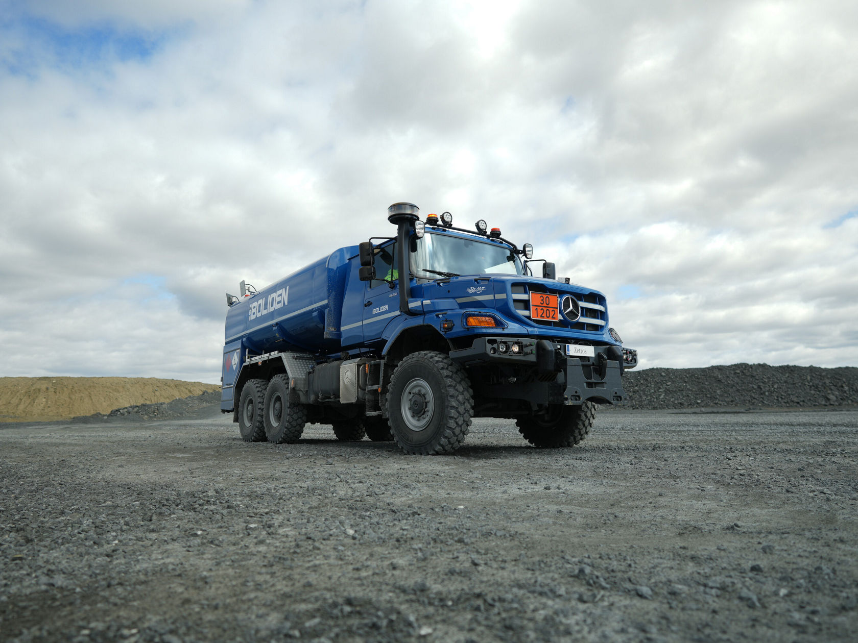 Ein blauer Mercedes-Benz Zetros Tankfahrzeug steht auf einer Schotterfläche.
