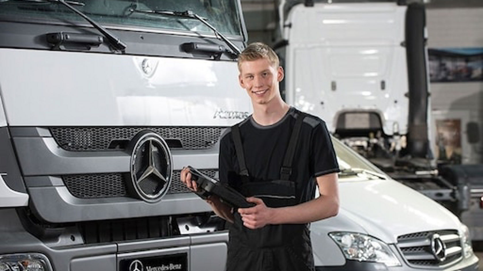 Kfz-Mechatroniker in der Werkstatt mit Ipad in der Hand