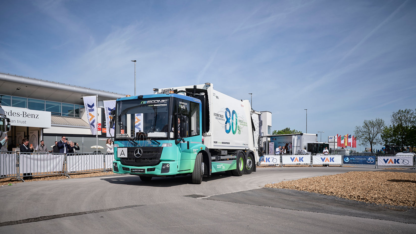 Mercedes-Benz eEconic Future Truck fährt auf der IFAT vor applaudierendem Publikum vor.
