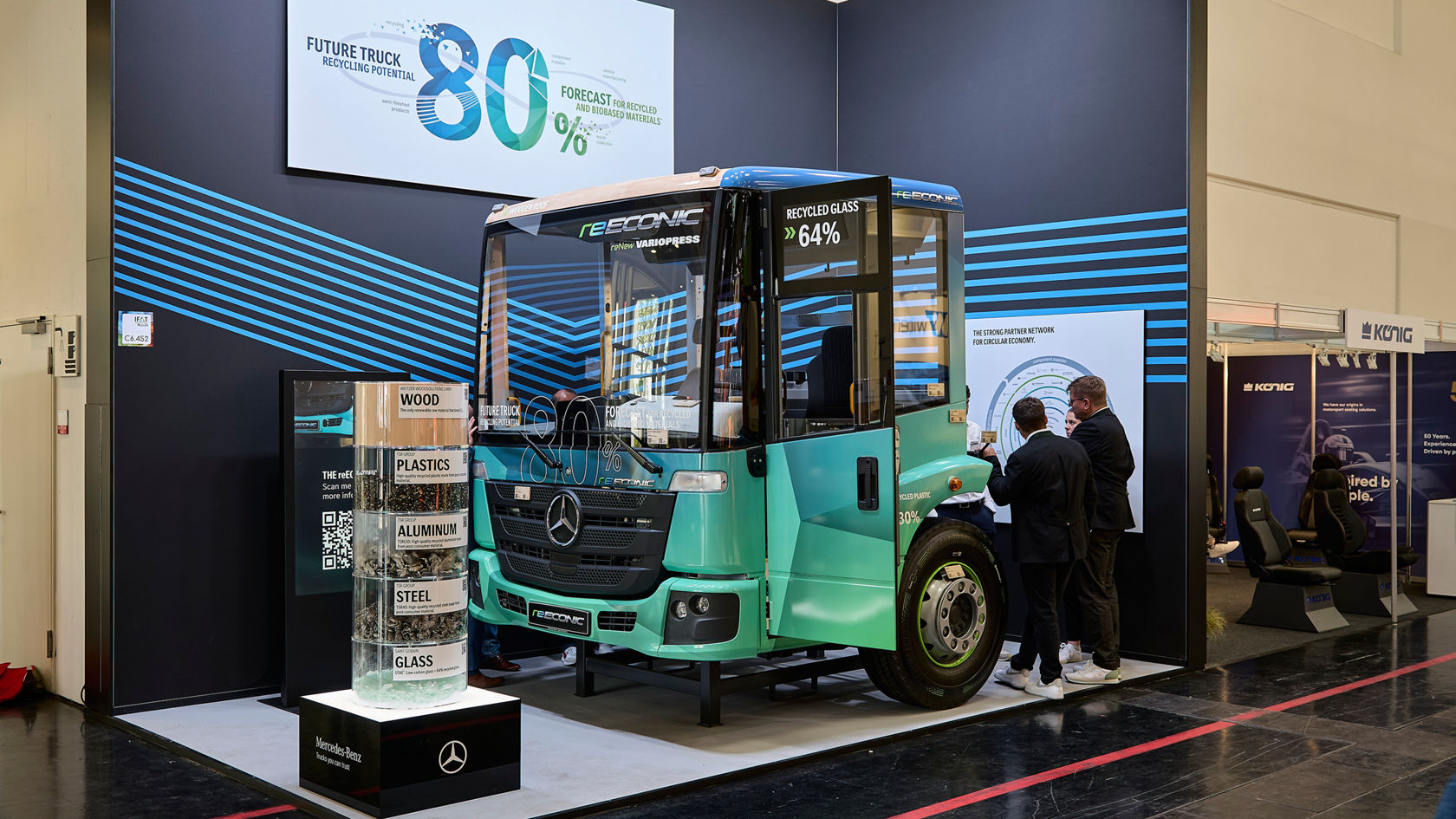 Mercedes-Benz eEconic Future Truck steht auf der IFAT mit Materialproben und Besuchern im Hintergrund.