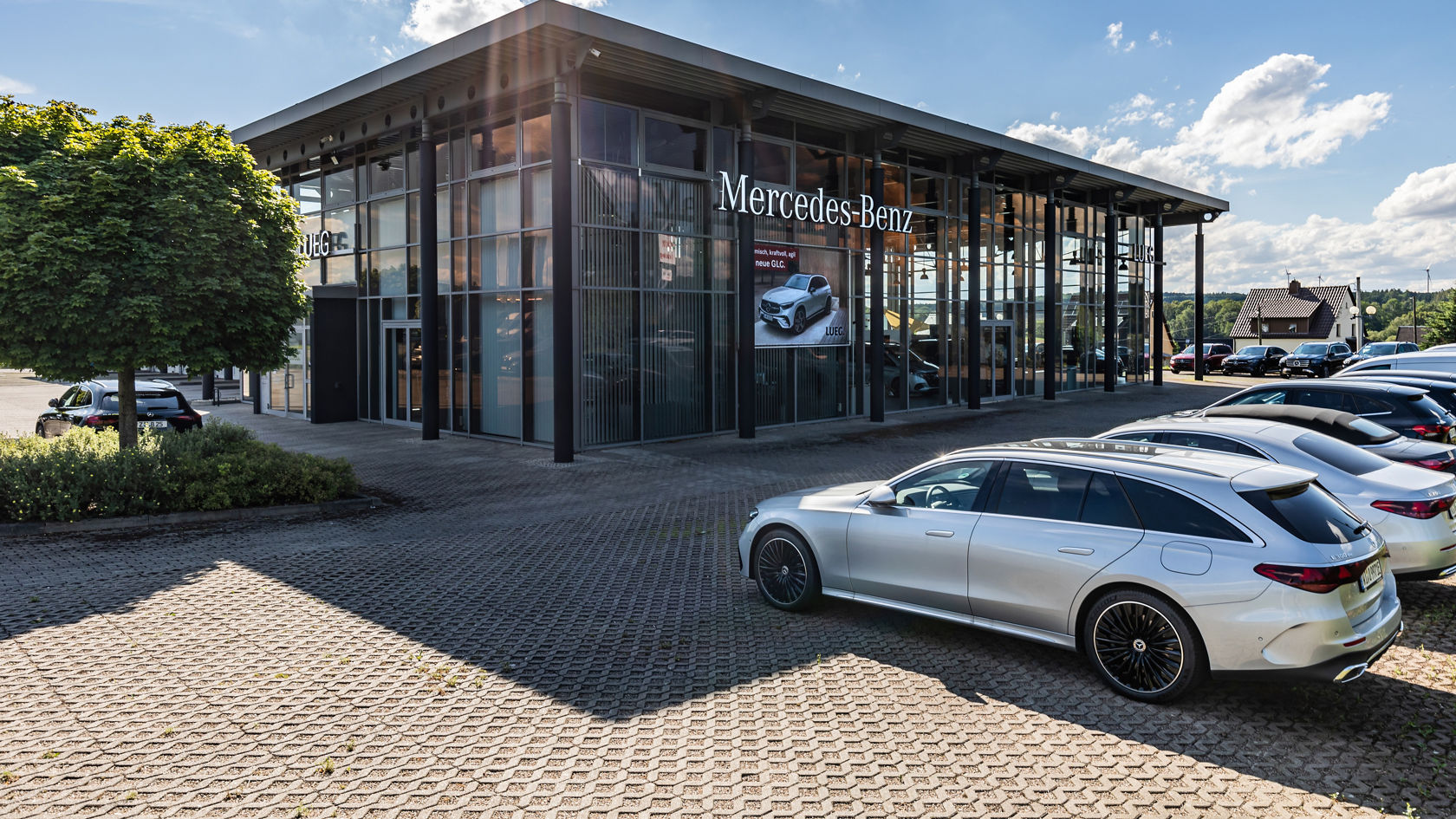Autohaus Bernsdorf, Glas komplett mit angrenzender Werkstatt, Mercedes-Benz Beschilderung, Fahrzeuge vor dem Autohaus 