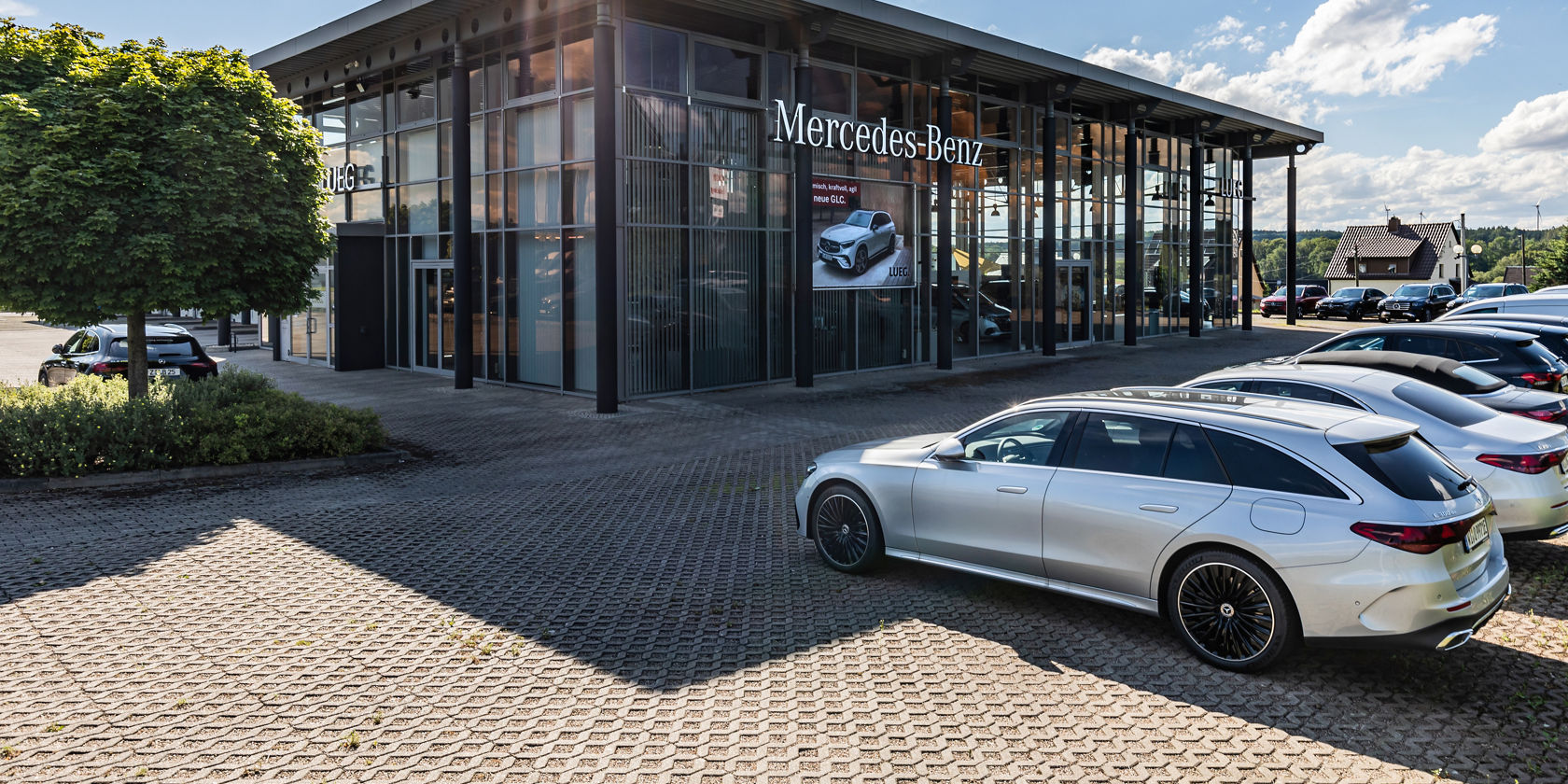 Autohaus Bernsdorf, Glas komplett mit angrenzender Werkstatt, Mercedes-Benz Beschilderung, Fahrzeuge vor dem Autohaus 