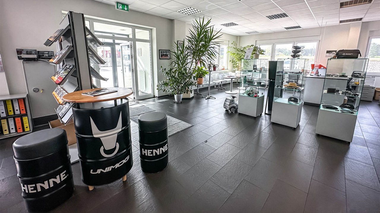 Foyer bei Henne Nutzfahrzeuge in Wurmannsquick mit Sitzecke und Vitrinen voll von Unimog und Mercedes-Benz Merchandise