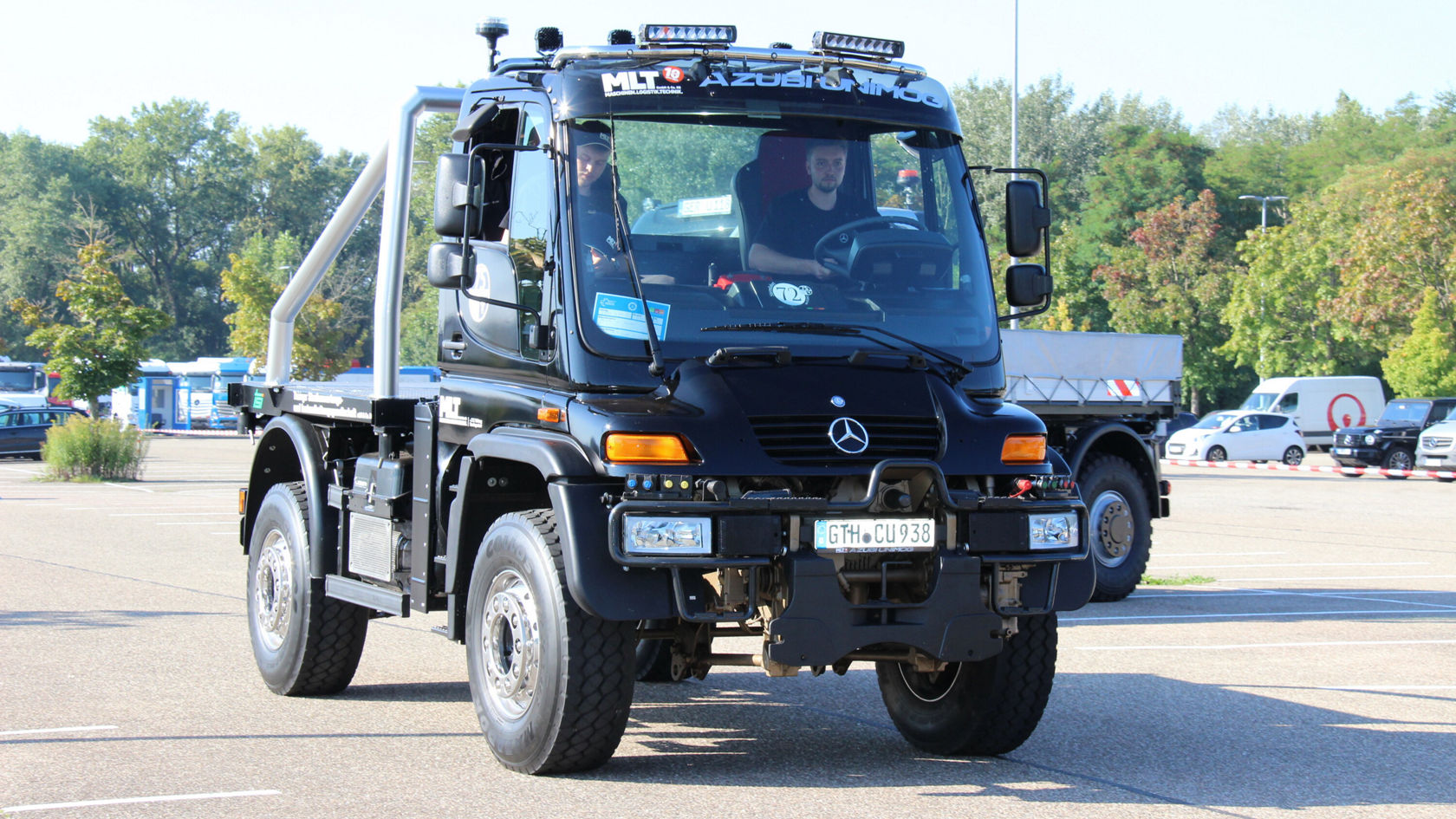 Ein schwarzer Mercedes-Benz Unimog steht auf einem Parkplatz.