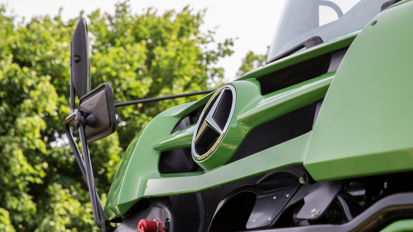 Close-up of the radiator grille of a green Mercedes-Benz Unimog.
