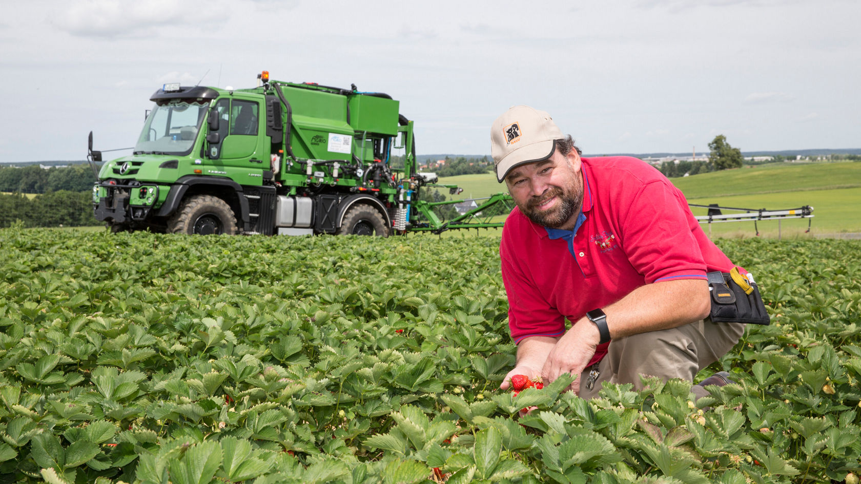 Harald Funck has good reason to smile: his fields are full of bright red, plump, sweet strawberries.