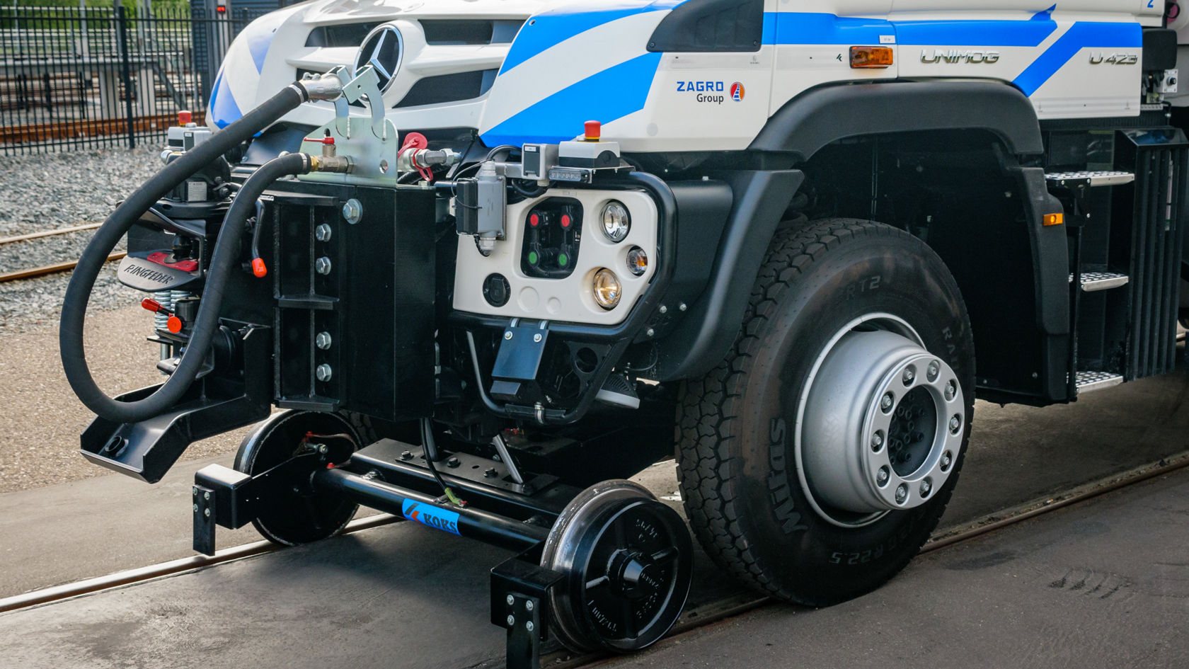 Der Mercedes-Benz Unimog steht auf Schienen und zeigt seine Antriebseinheit mit sichtbaren Komponenten, einschließlich einer Radachse und technischen Anschlussstellen.