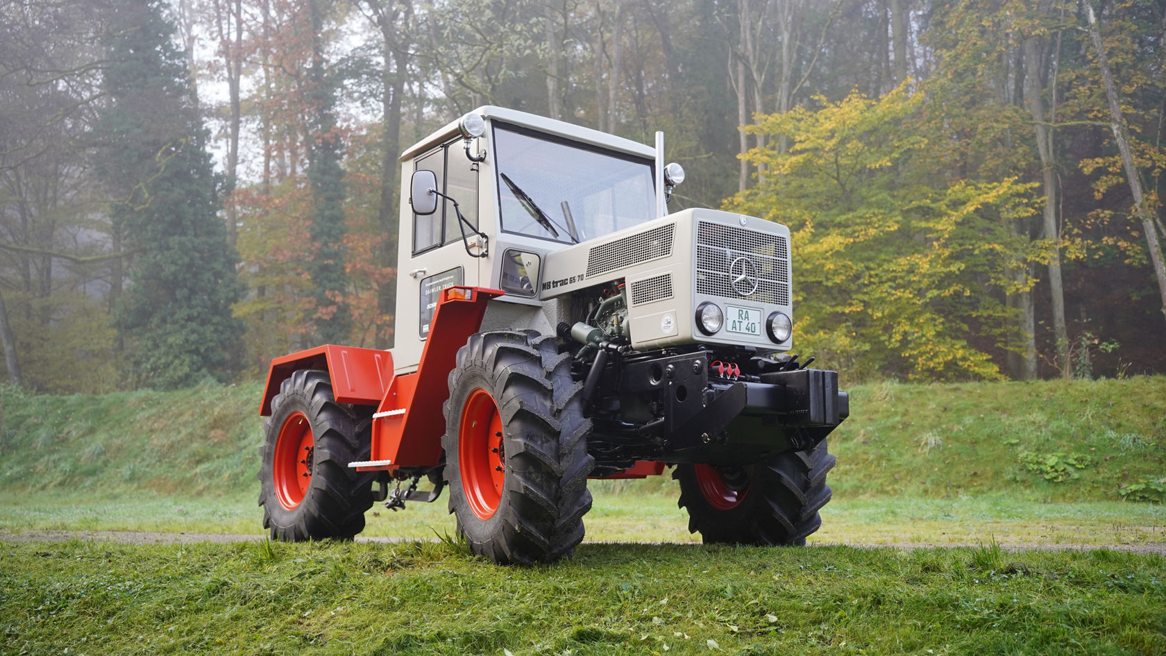 Ein Mercedes-Benz Unimog, der aus der Nähe fotografiert wurde, zeigt seine markante Frontpartie und den Kühlgrill, umgeben von einem nebligen Waldbereich.