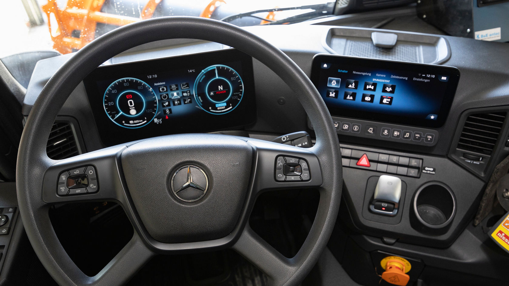 Der Innenraum eines Mercedes-Benz eActros mit Lenkrad, digitalen Tachometern und einem Infotainment-Bildschirm.