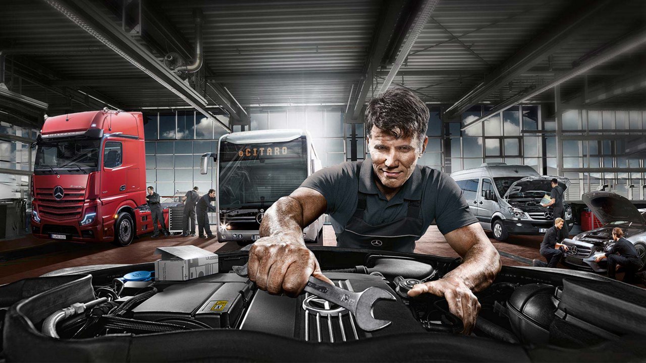 Een monteur sleutelt aan een motor.