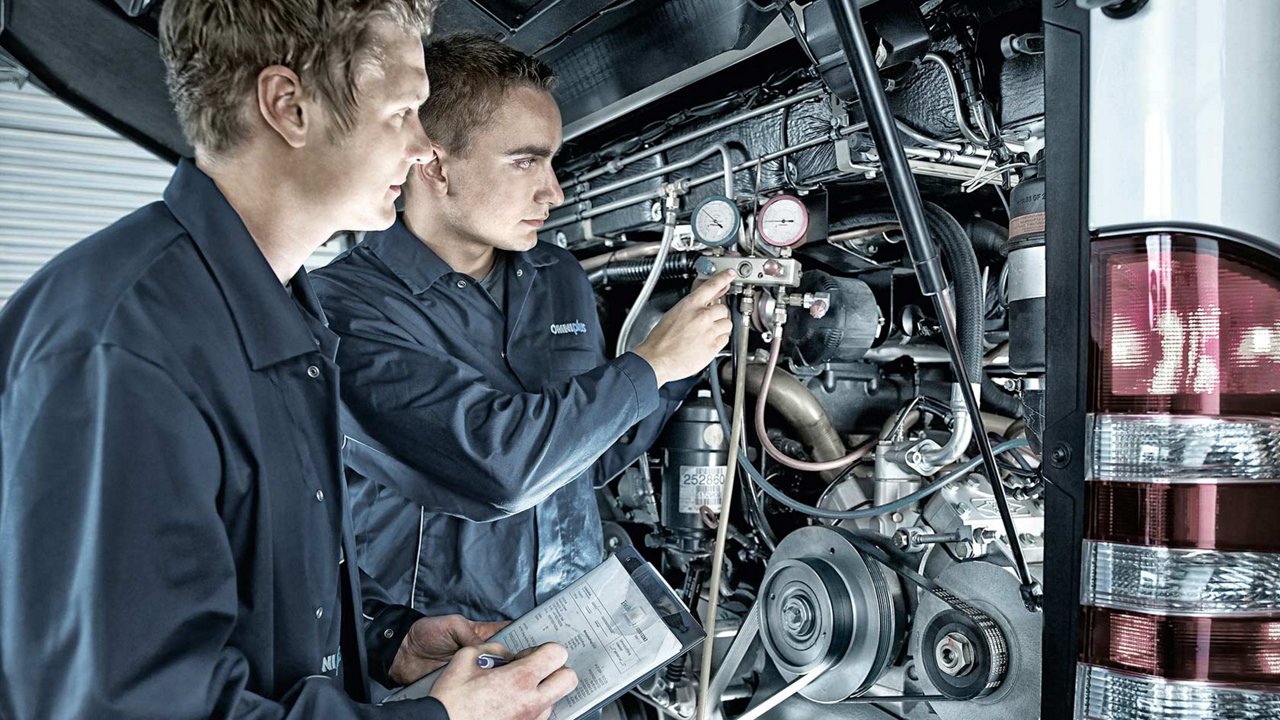 Op deze foto sleutelen 2 monteurs aan de motor van een Mercedes-Benz Truck.
