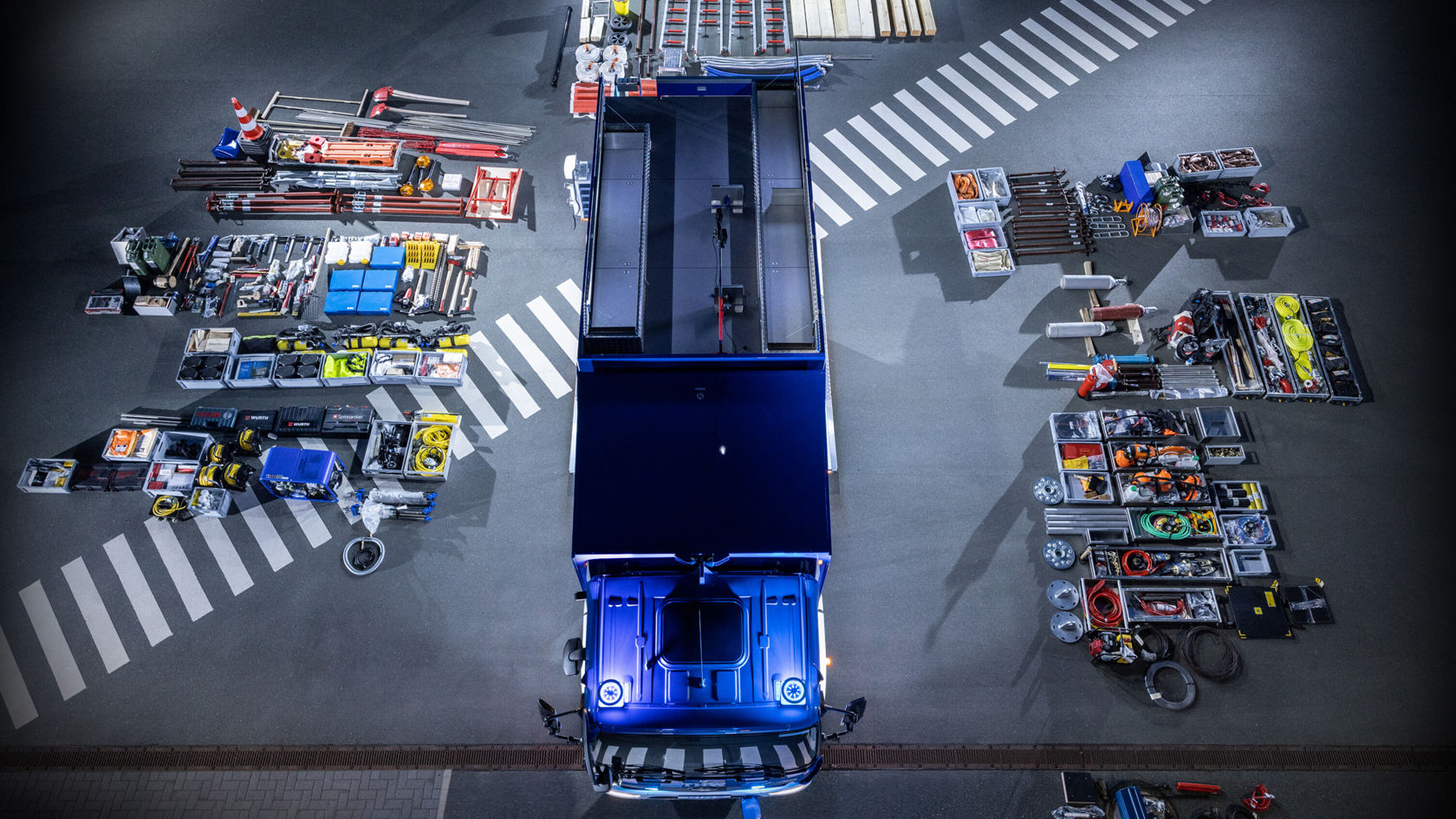 Vue de dessus d'un Atego Mercedes‑Benz. Le véhicule se trouve au centre d'un parking, entouré de différents outils.