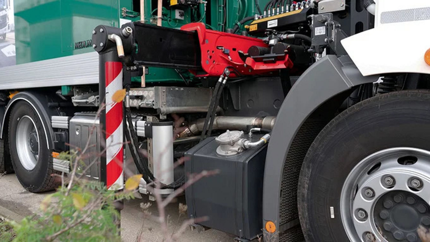 Close-up of an Econic with a red hydraulic arm and various technical components.