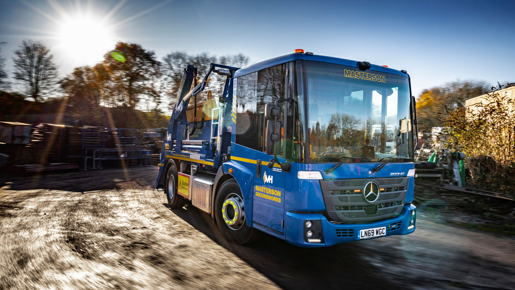 Mercedes-Benz Lastwagen in blauer Lackierung, steht auf einer Baustelle, bereit für Einsätze im Bereich Abfallentsorgung und Logistik.