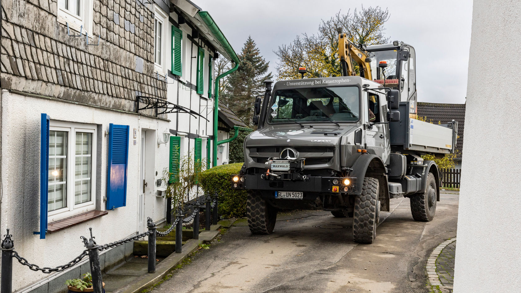 Unimog U 5023 drives through a village.