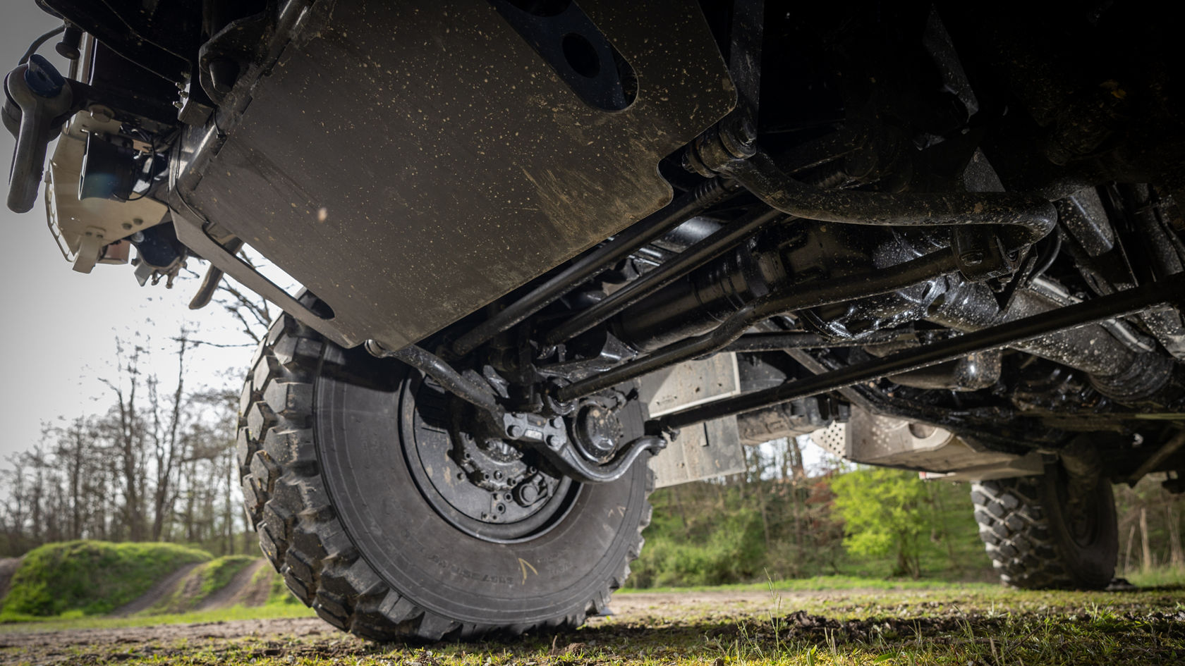 Vue de dessous d'un véhicule tout-terrain Mercedes‑Benz montrant la conception du train de roulement et les pneus tout-terrain. Adapté aux terrains exigeants et aux aventures tout-terrain.