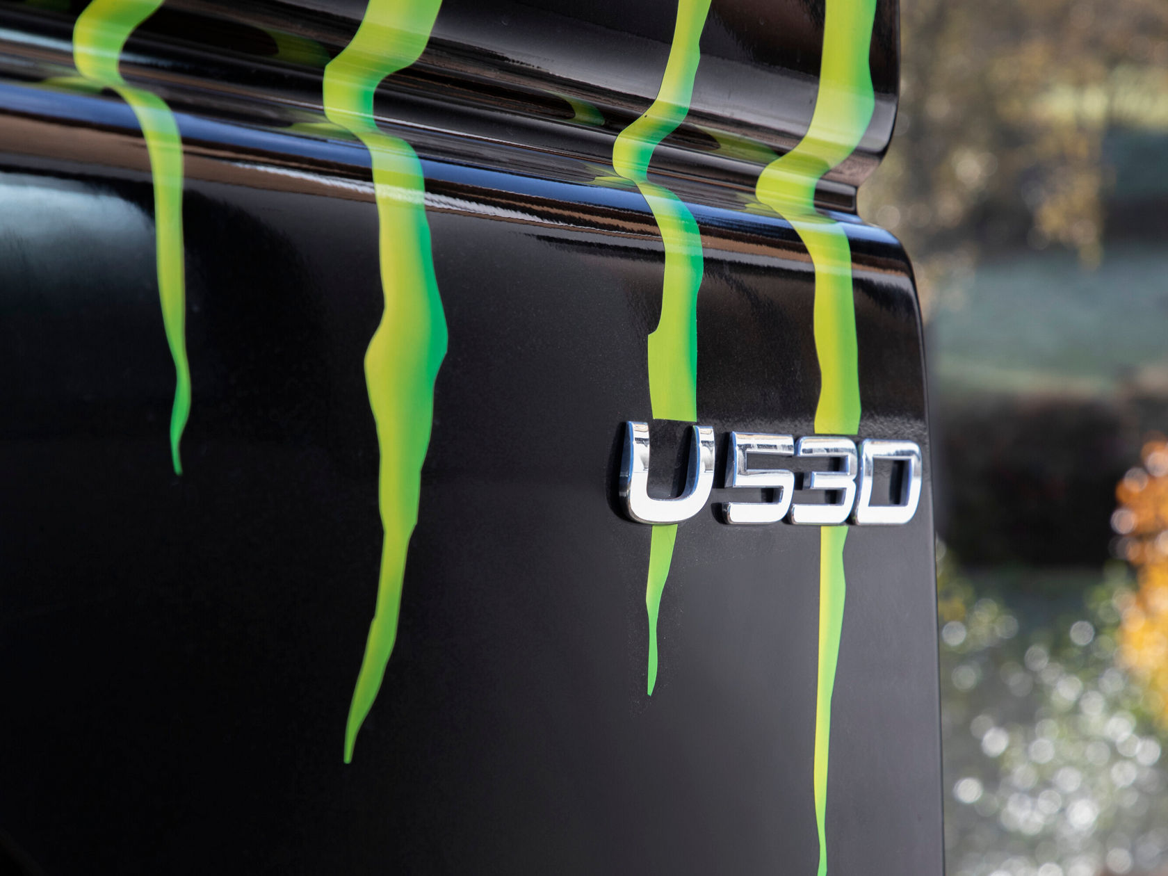 Schwarze Fahrzeugkarosserie mit auffälligen grünen Streifen und dem Schriftzug "U530", was einen sportlichen und dynamischen Look vermittelt.