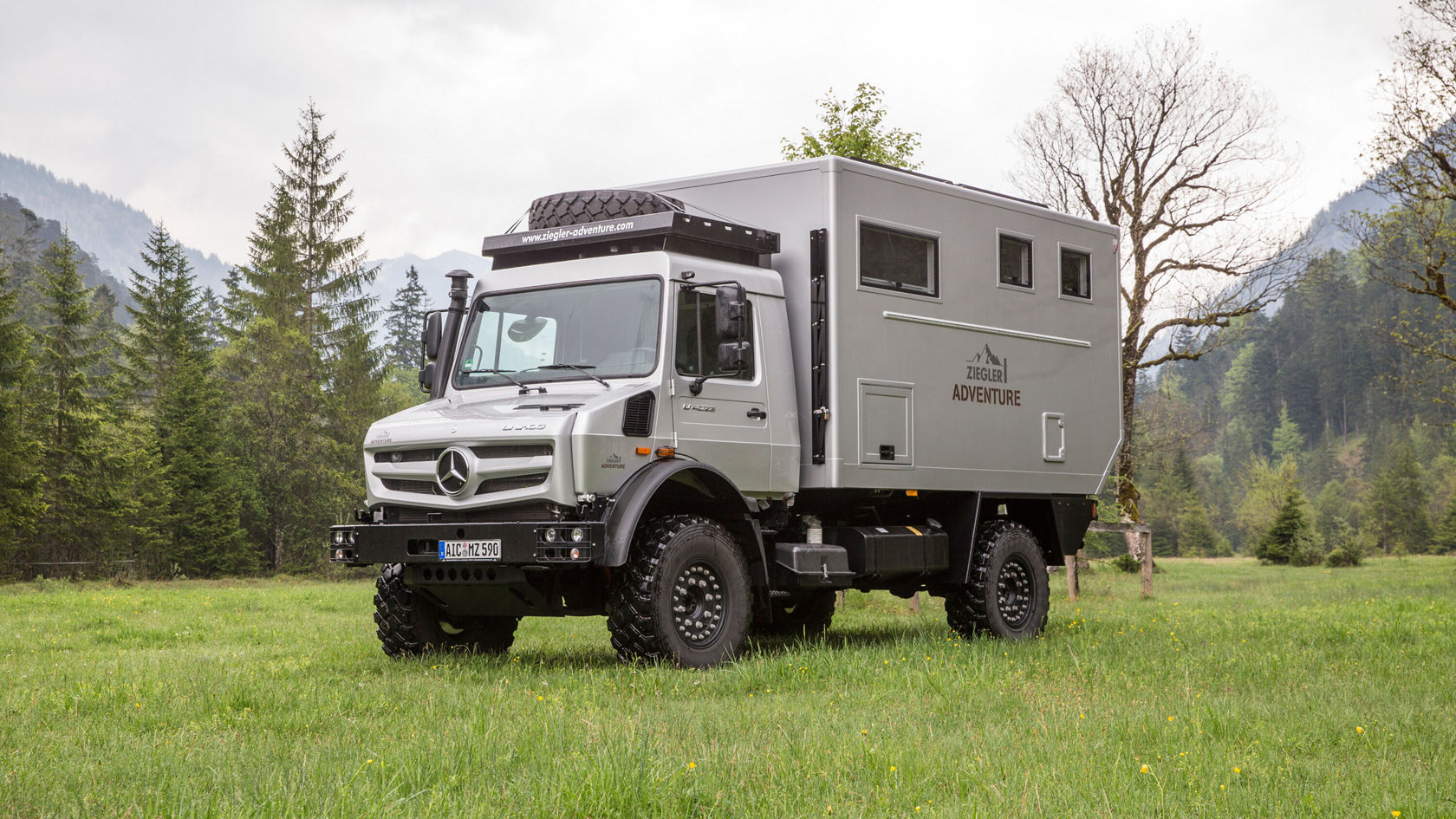 Ein Unimog Camper stehr auf einer Wiese.