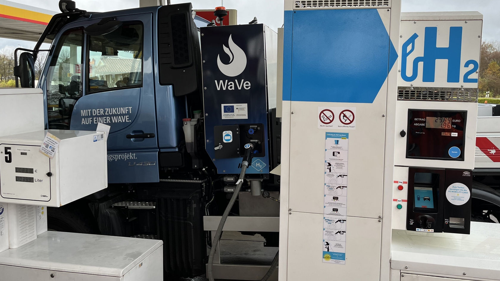 Un Unimog Mercedes‑Benz est stationné à une station‑service d'hydrogène, équipée d'une pompe spéciale pour le ravitaillement en H2 respectueux de l'environnement.