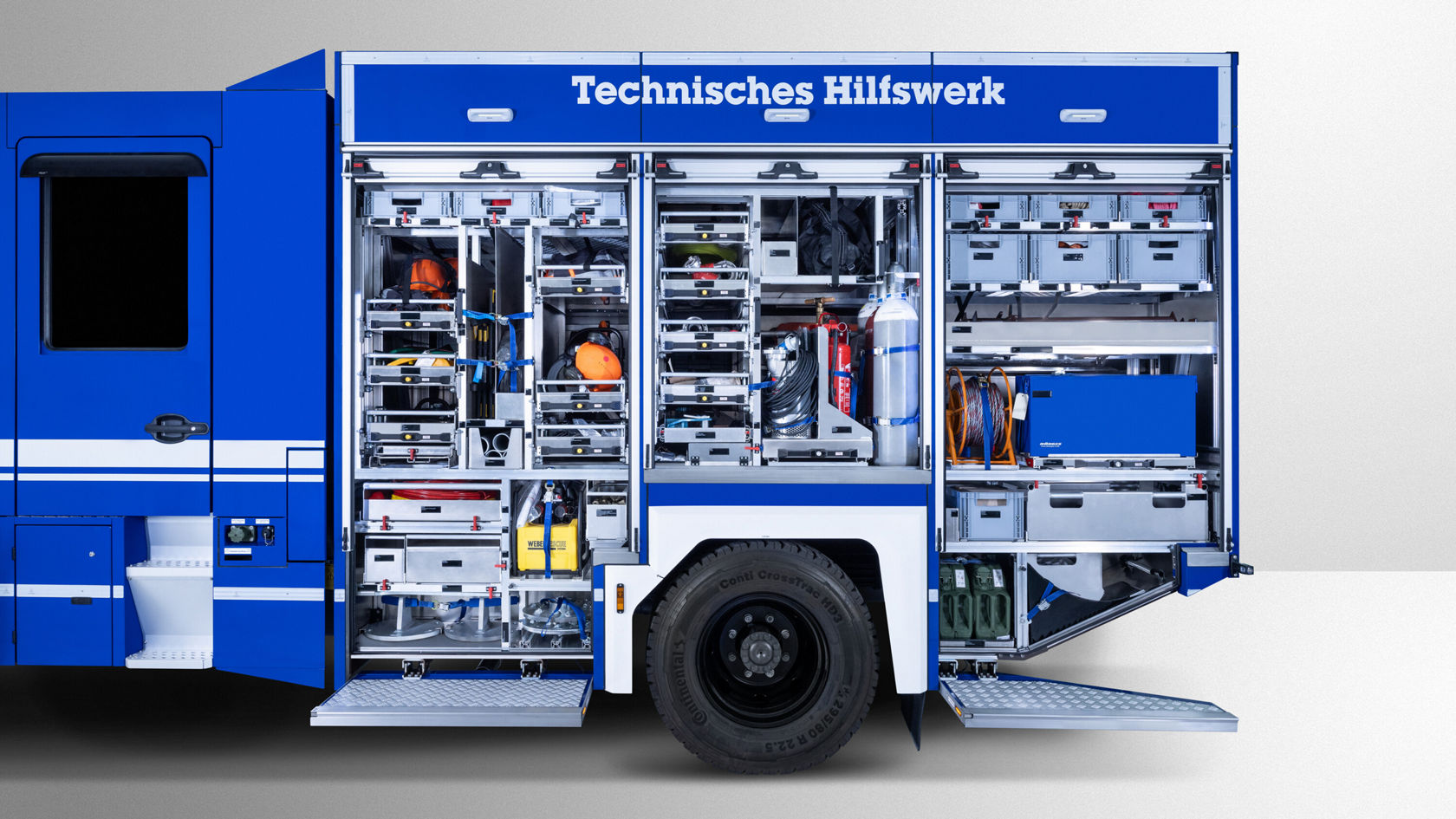 Un Atego Mercedes‑Benz avec des compartiments latéraux ouverts montrant différents outils et équipements du Technischen Hilfswerk.