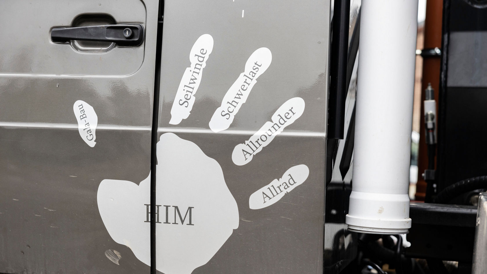 On the door of a Mercedes-Benz vehicle, several words are arranged in speech bubbles, including terms such as "all-wheel drive", "heavy-duty" and "all-rounder".