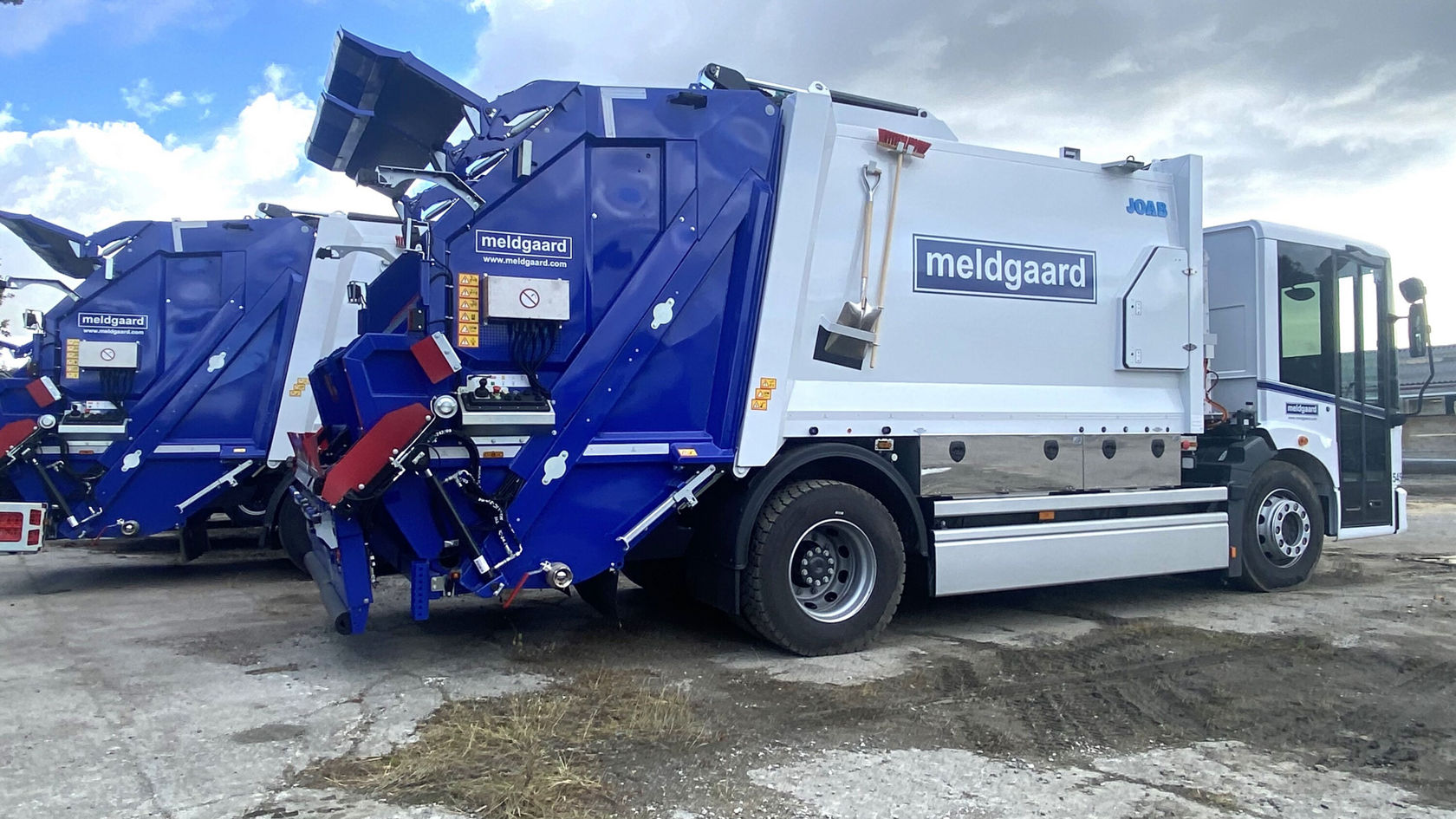 Ein Mercedes-Benz Econic Müllfahrzeug auf einer möglicherweise urbanen Fläche, gekennzeichnet durch die Aufschrift "meldgaard". Der Lkw zeigt eine moderne, funktionale Bauweise zur Abfallentsorgung.