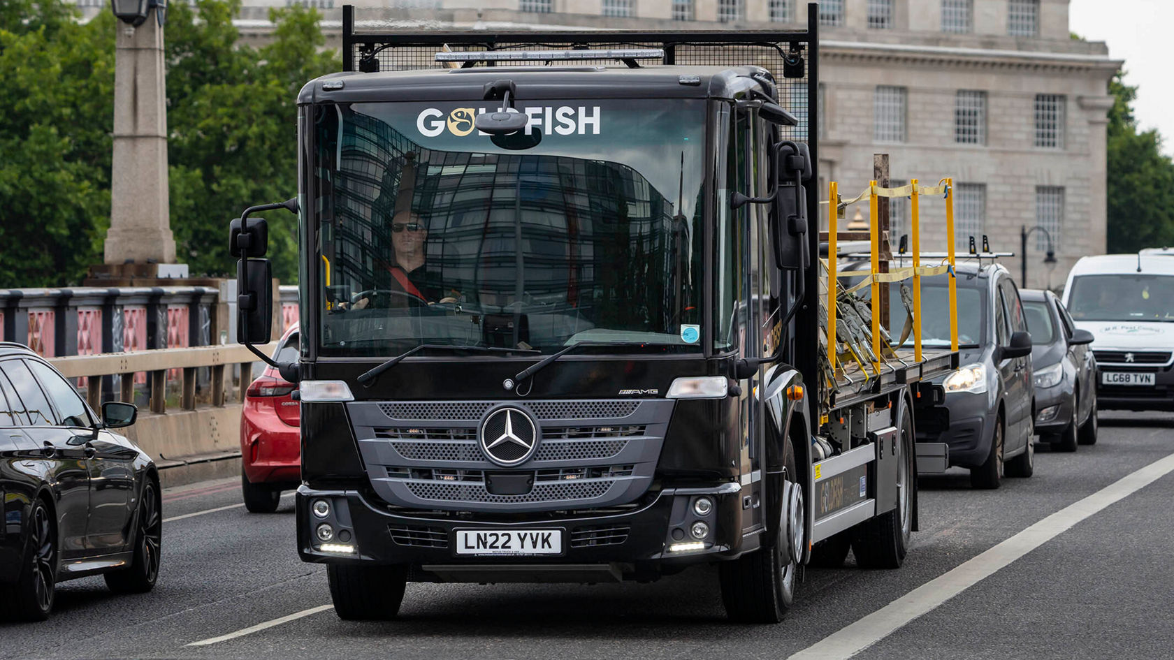 Schwarzer Mercedes-Benz Econic fährt auf einer belebten Straße.