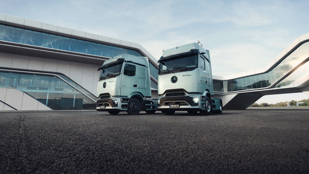 Zwei Mercedes-Benz Actros L mit ProCabin vor moderner Architektur.