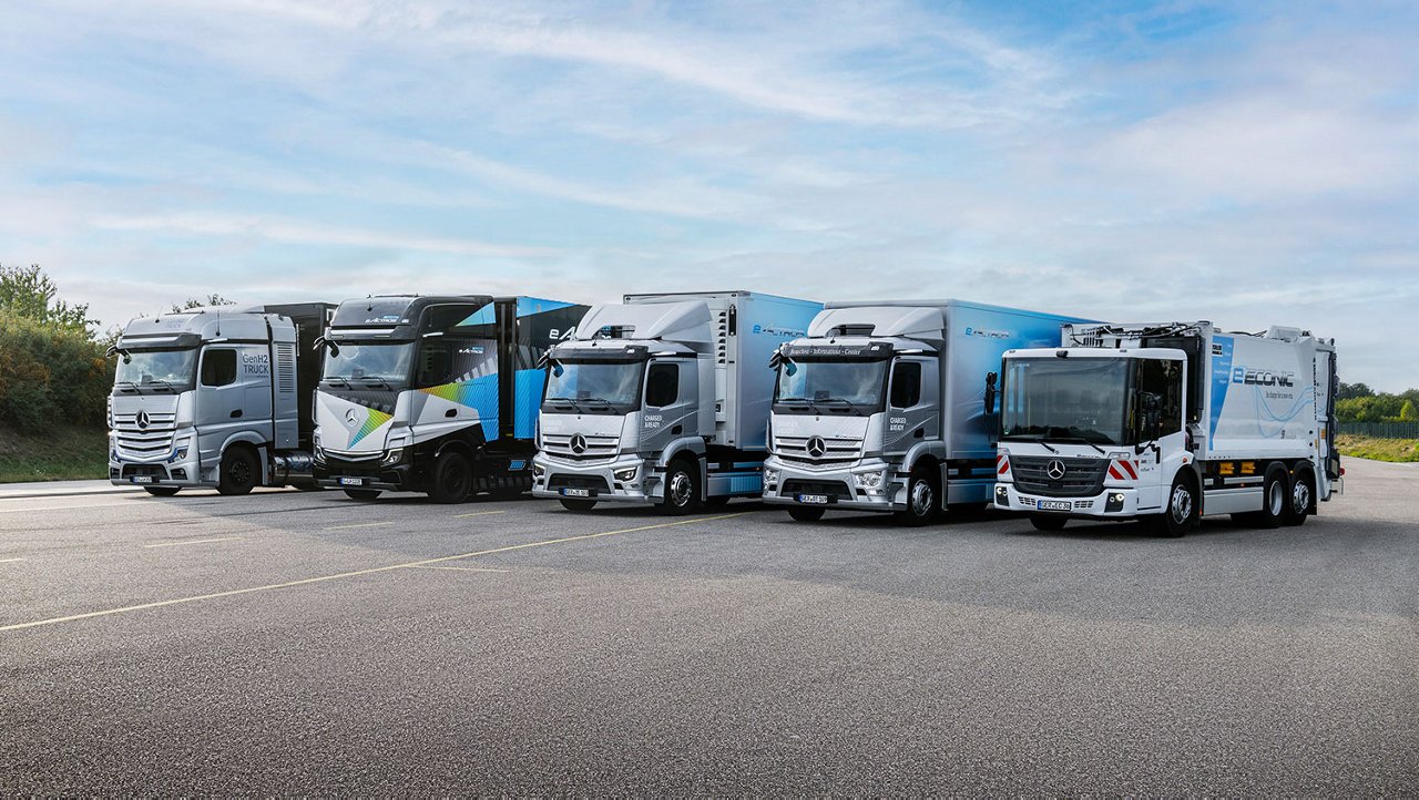 Mercedes-Benz LKW-Range in Reihe auf einem Testgelände bei sonnigem Wetter.