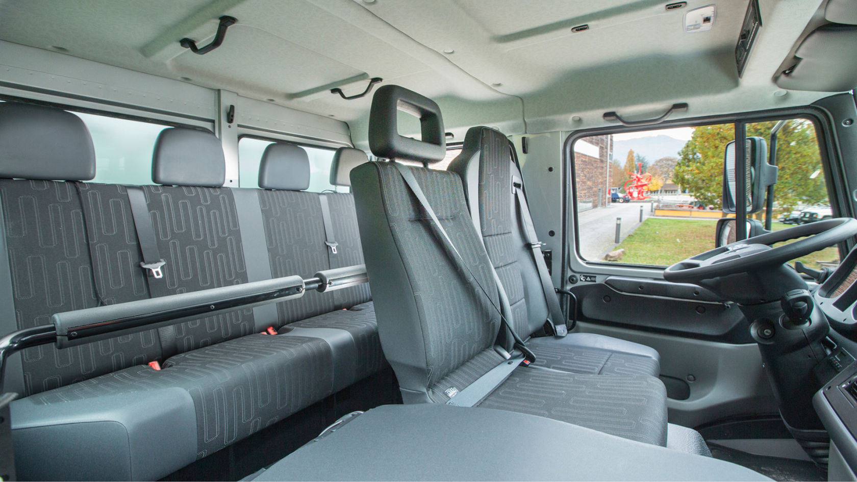 Het interieur van een Unimog met meerdere zitplaatsen en veiligheidsgordels.