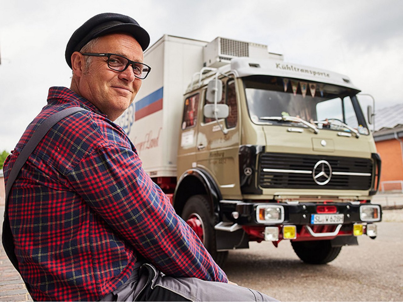 Homme devant un camion ancien.