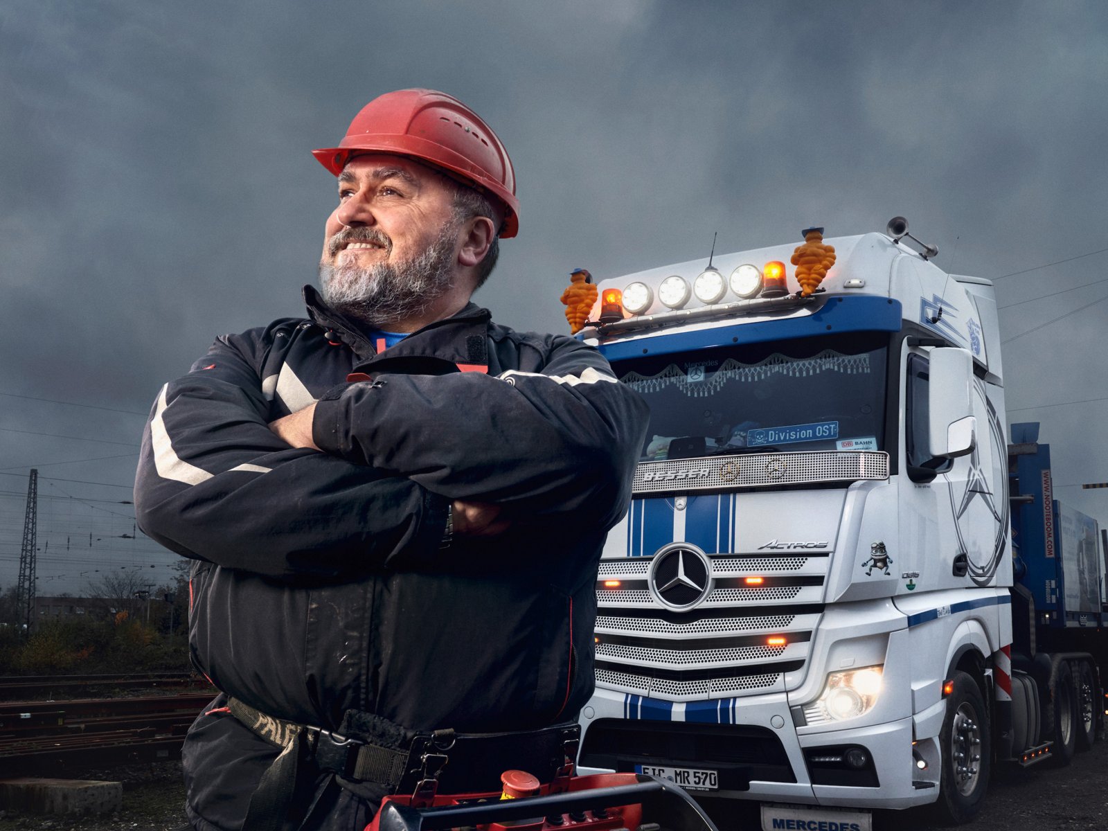 Uomo in piedi davanti a un autocarro.