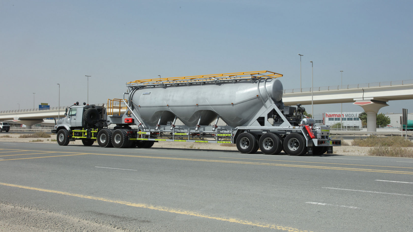 A Mercedes-Benz Zetros is standing on the road with a silver silo semi-trailer designed for the transport of bulk goods.