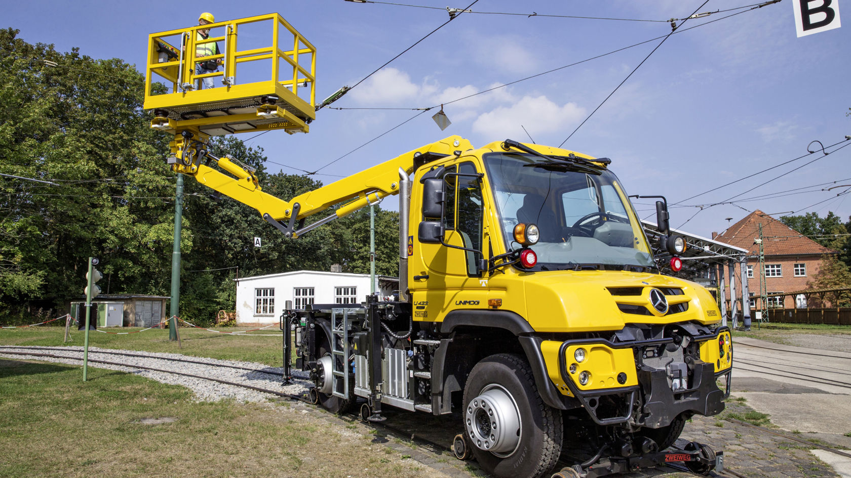 Kollane Unimog tõstetava tööplatvormiga, mida kasutatakse depoopiirkonnas õhuliinide hooldustöödeks.
