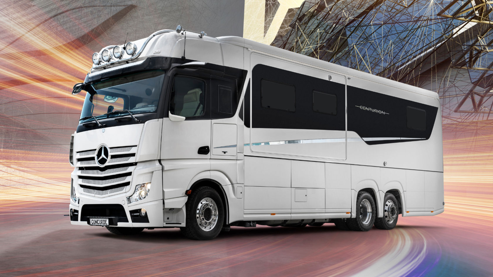 Das Bild zeigt einen luxuriösen, weißen Concorde Centurion Reisemobil auf einem glatten Untergrund mit einem abstrakten Hintergrund. Das Reisemobil basiert auf einem Actros-Chassis und verfügt über eine hohe Kabine mit Zusatzscheinwerfern auf dem Dach. Die Karosserie ist langgestreckt und mit schwarzen Fenstern versehen, während der Schriftzug "CENTURION" auf der Seite zu sehen ist. Der Hintergrund besteht aus einer Mischung aus abstrakten Linien und einer modernen Gebäudeansicht, was den luxuriösen Charakter des Fahrzeugs unterstreicht.