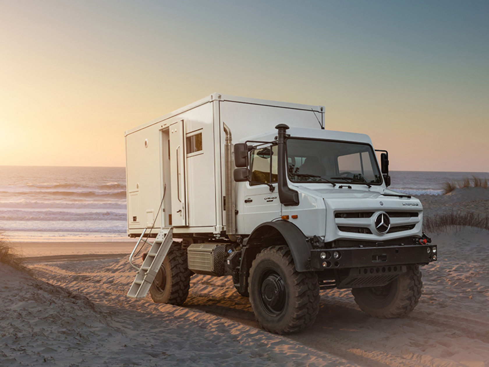 Un Unimog bianco sulla spiaggia. 