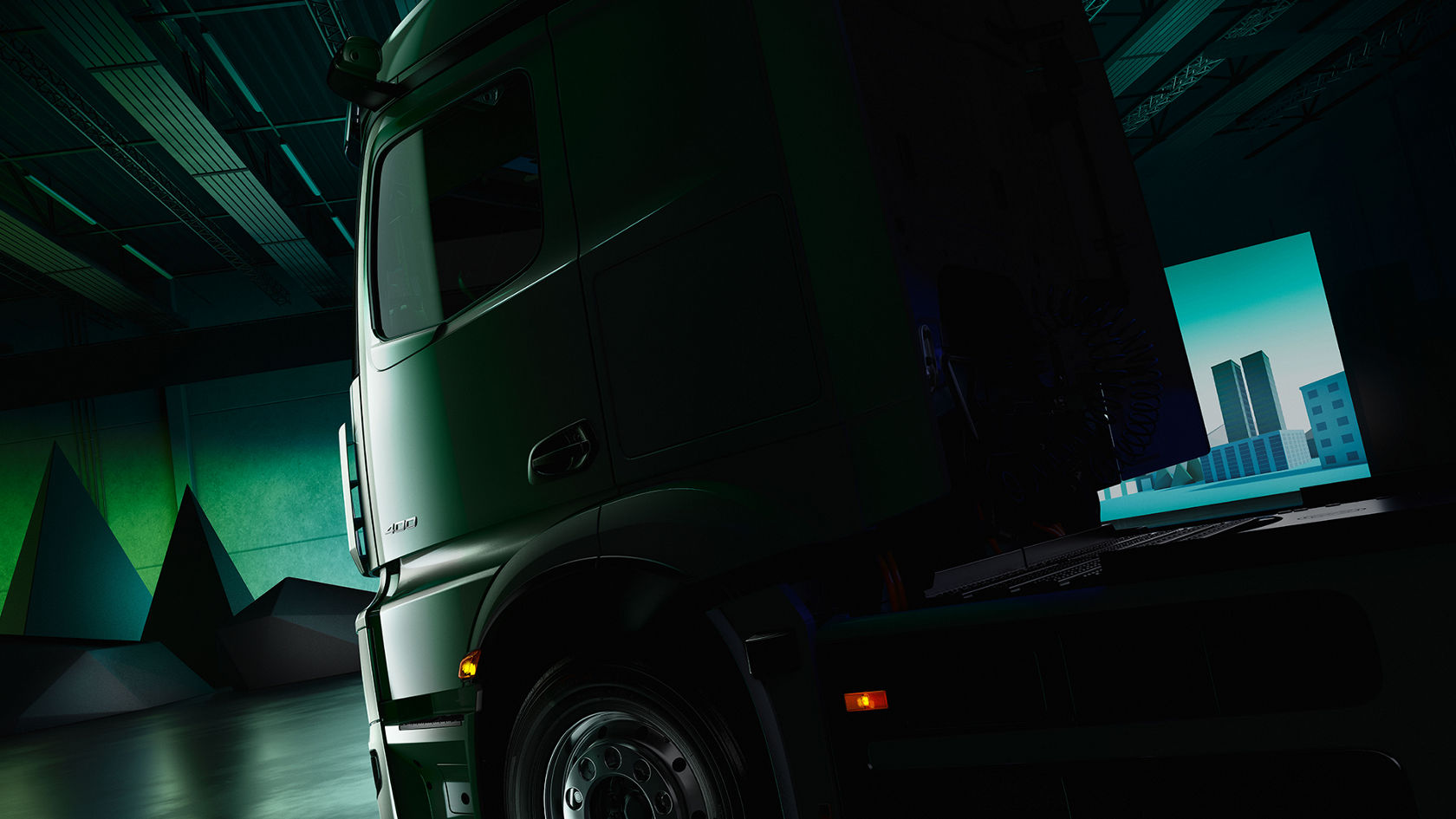 The image shows a truck from its rear, left side, standing in a dimly lit hall. In the background is a bright screen with a stylised city view, while light green strips of light run through the ceiling of the hall.