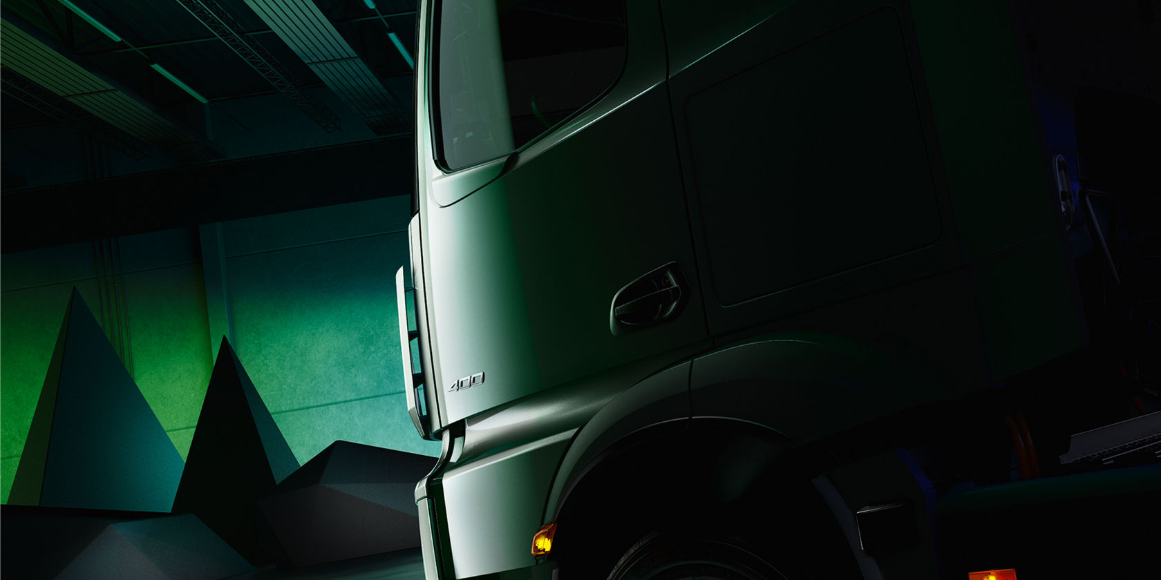 The image shows a detailed section of the side of a truck on which the silver number “400” is clearly visible. In the background is a bright green wall, which contrasts strongly with the dark vehicle.