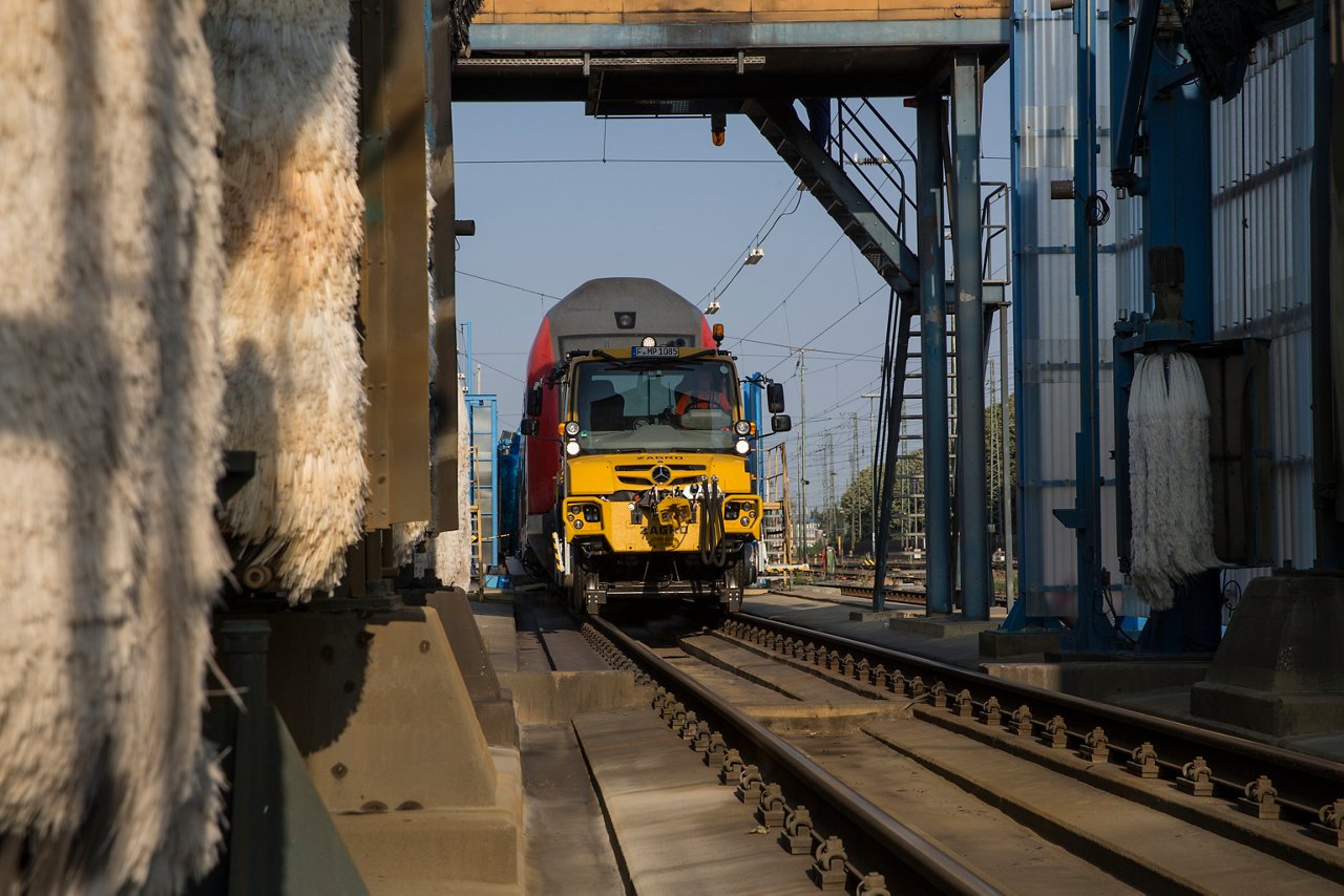 Unimog trekt een trein door de wasstraat.
