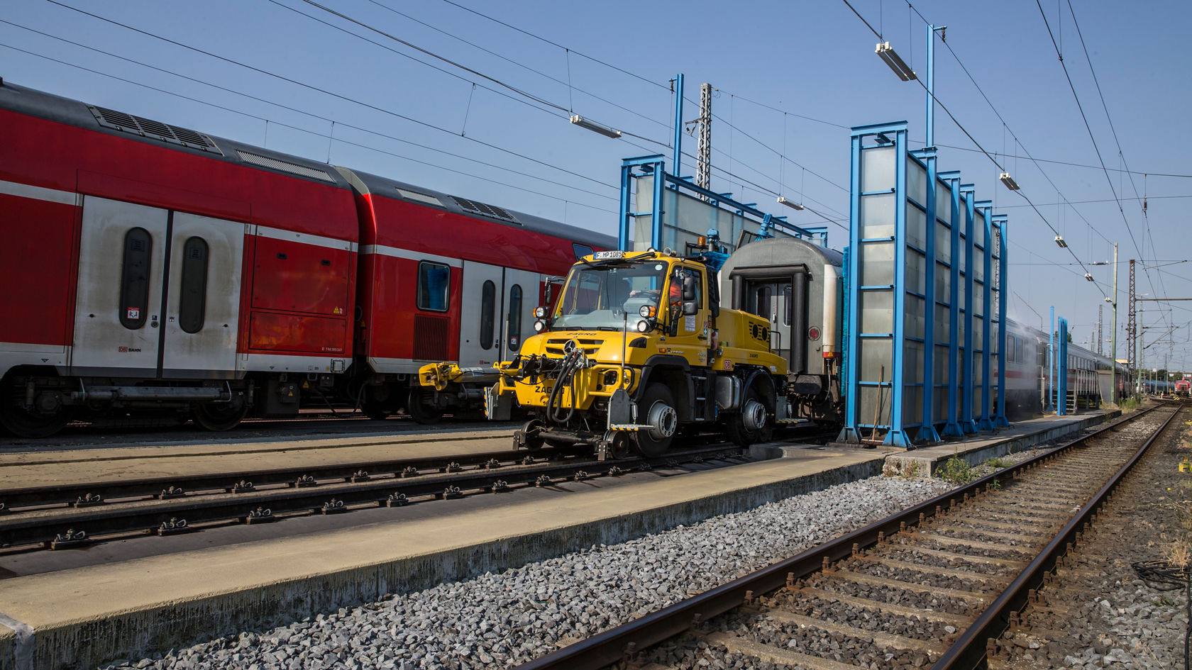 Unimog trekt een trein door de wasstraat.