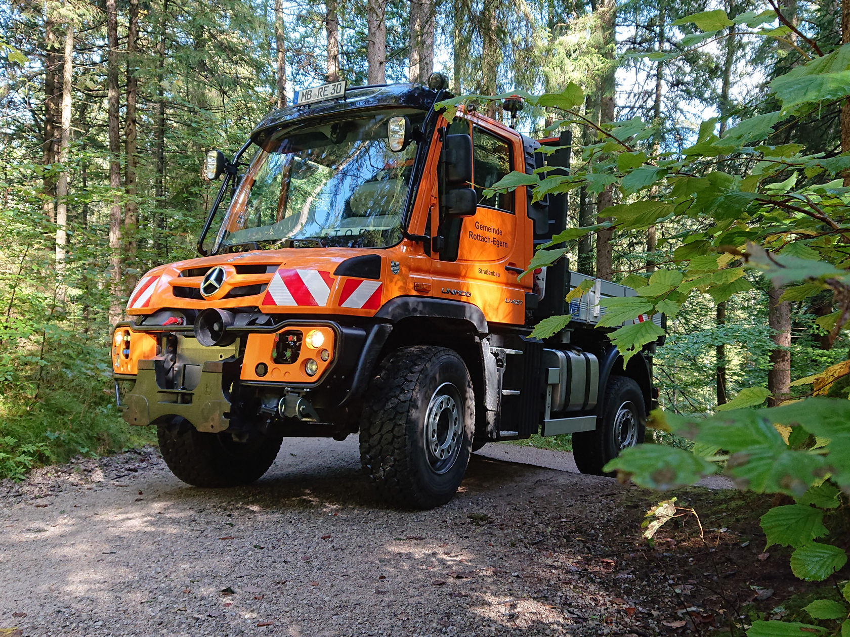 Kommunal Unimog in Orange auf einem Waldweg