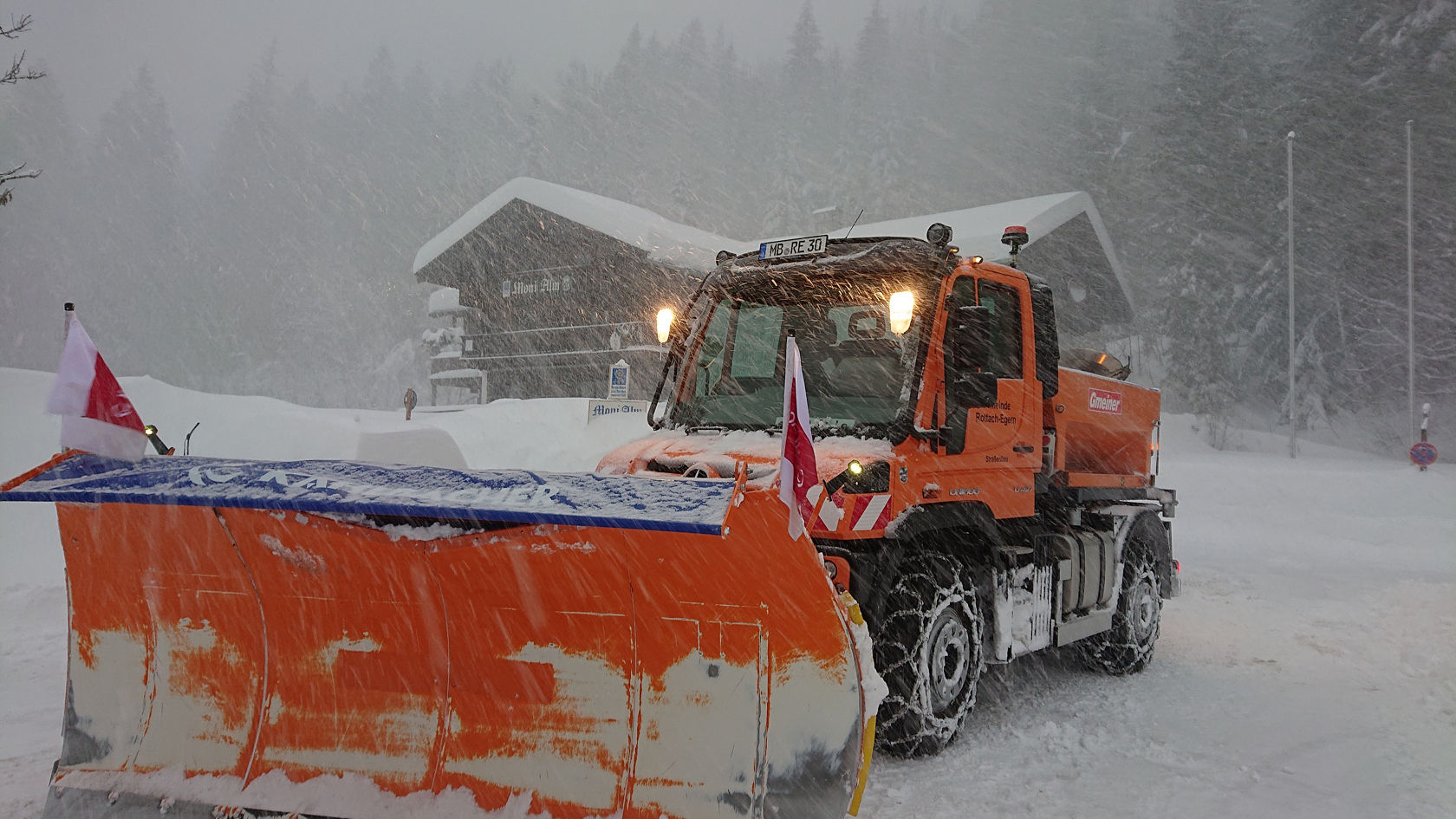 Unimog mit Schneepflug und Schneeketten im Schneechaos