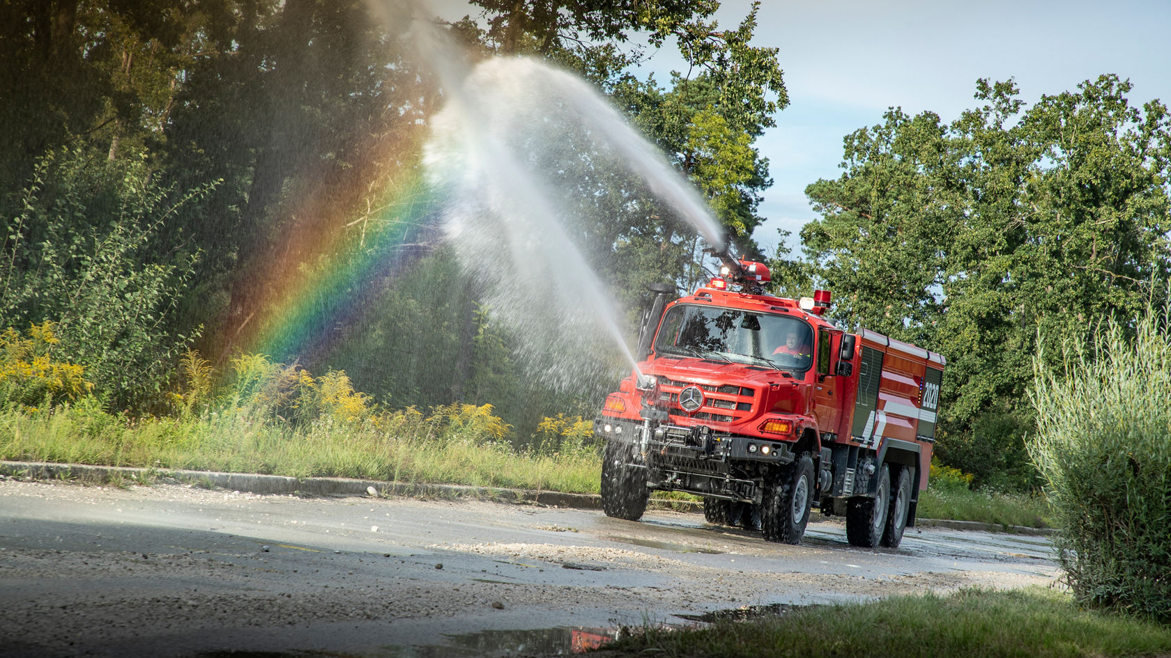 Feuerwehr Zetros mit aktiven Sprühdüsen fährt auf der Straße