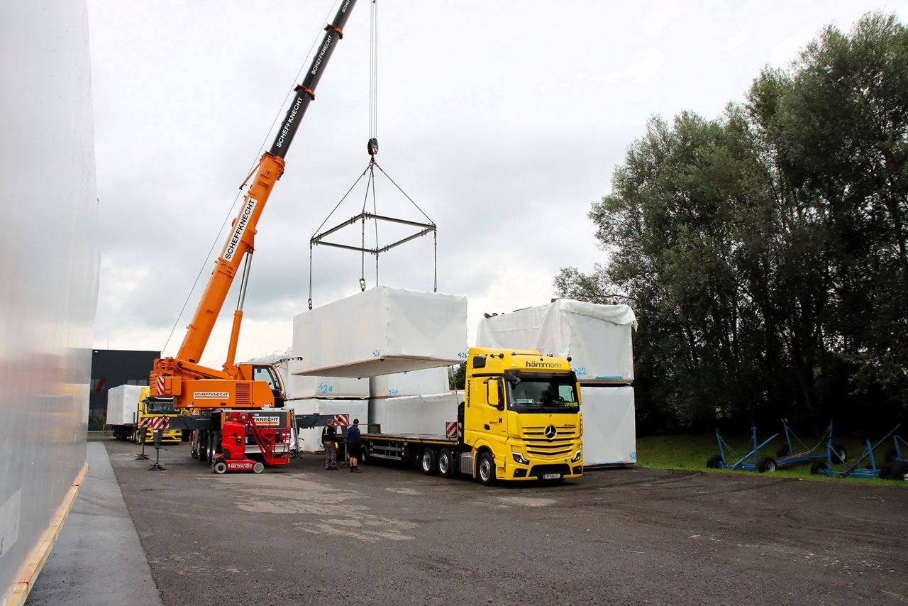 Der Actros L mit einem orangen Kran entladen.