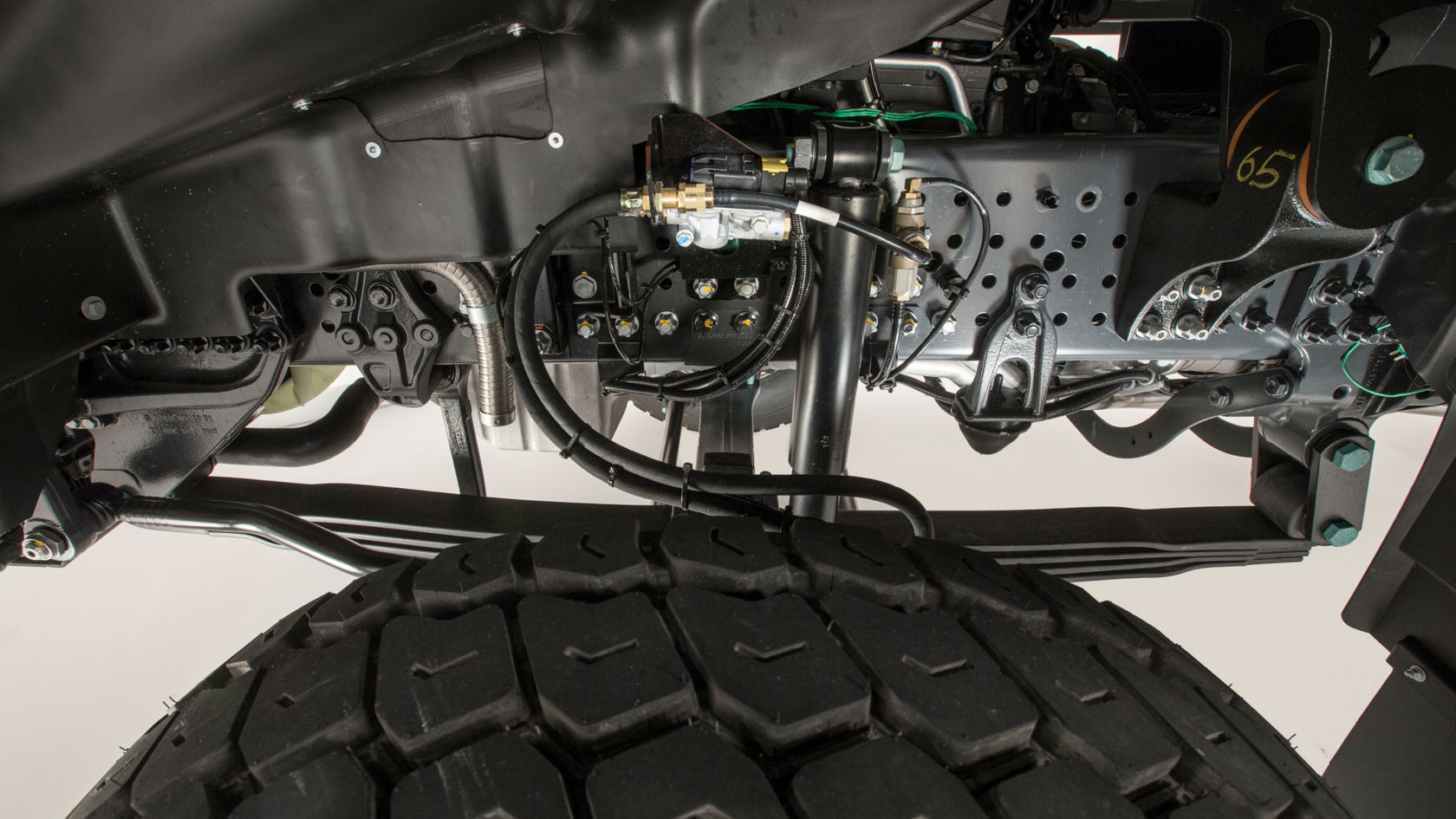 Close-up of the reinforced ladder frame. Part of a tyre is visible in the foreground.