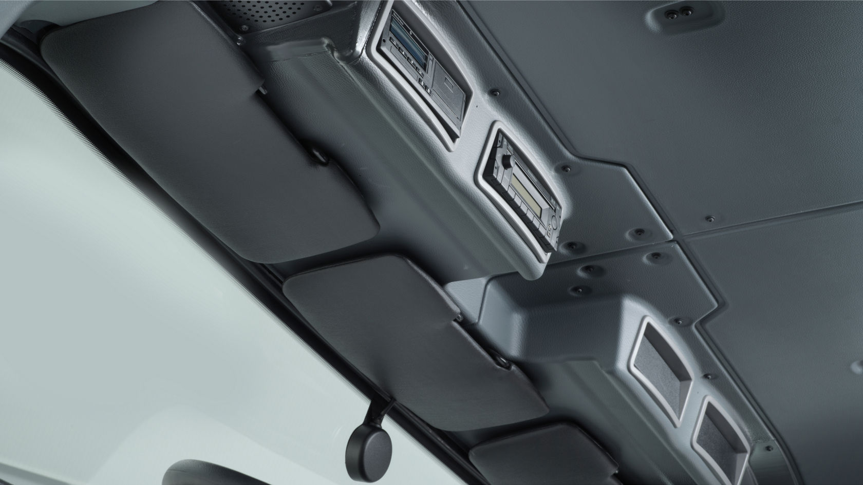 Upper area of the Zetros interior with sun visors, radio and stowage compartments. Part of the windscreen is visible.